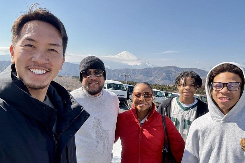 A group of people standing outdoors with a mountain in the background. 2