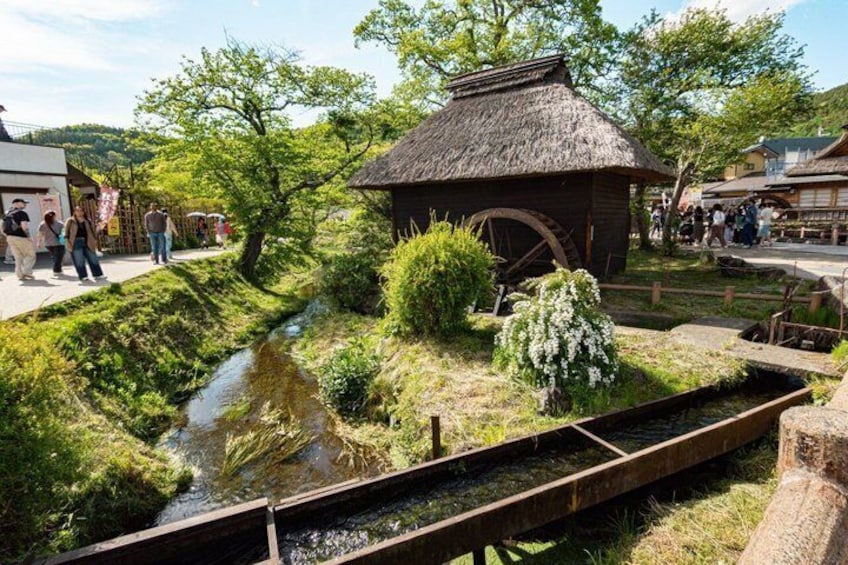 Un moulin à eau traditionnel, une petite construction en bois avec un toit de chaume et un étroit canal d’eau. 4