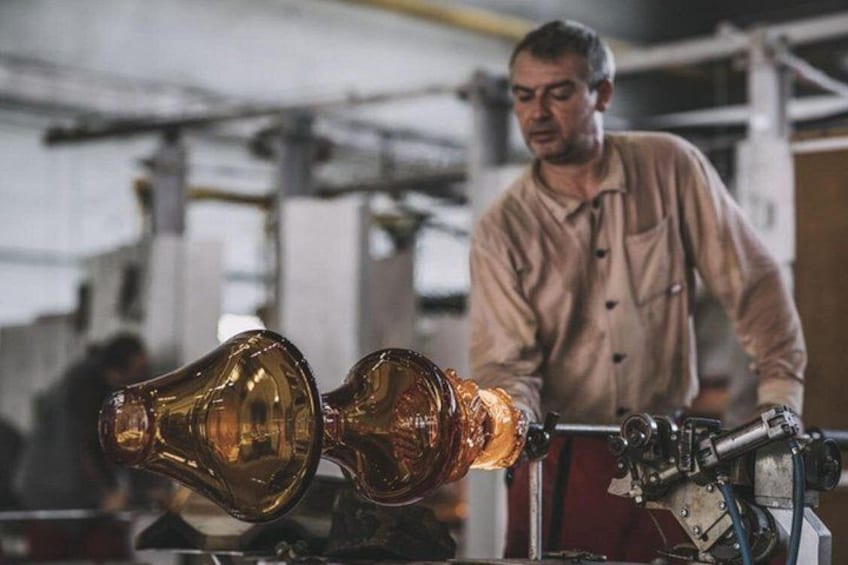 A person working with a glass blowing machine in a workshop. 3