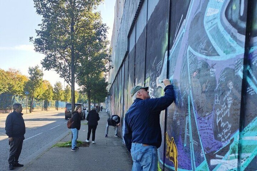 A person painting a mural on a building wall. 1