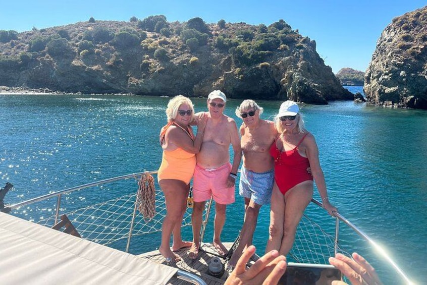 A group of people on a boat near a rocky coastline. 4