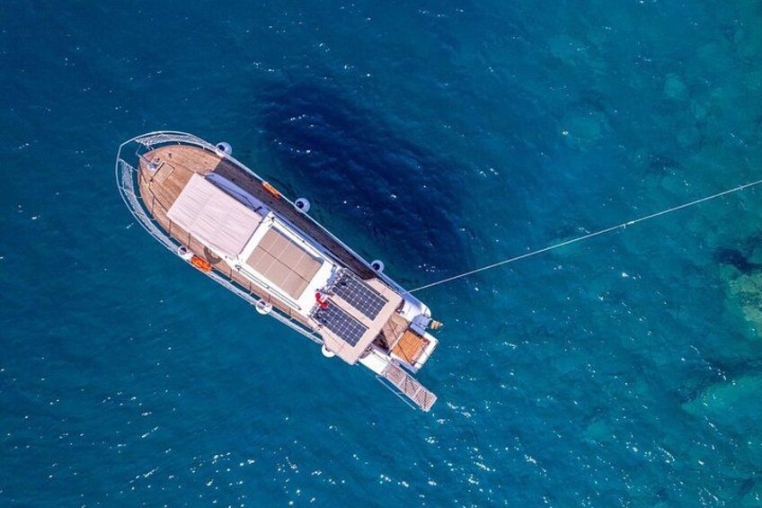 An aerial view of a boat with a deck, solar panels, and a flag. 2