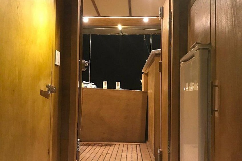 Un pasillo estrecho con puertas de madera y suelo de baldosas. 4