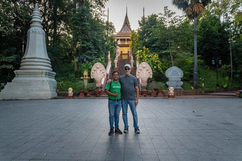 Two people standing in a park with a temple in the background. 5