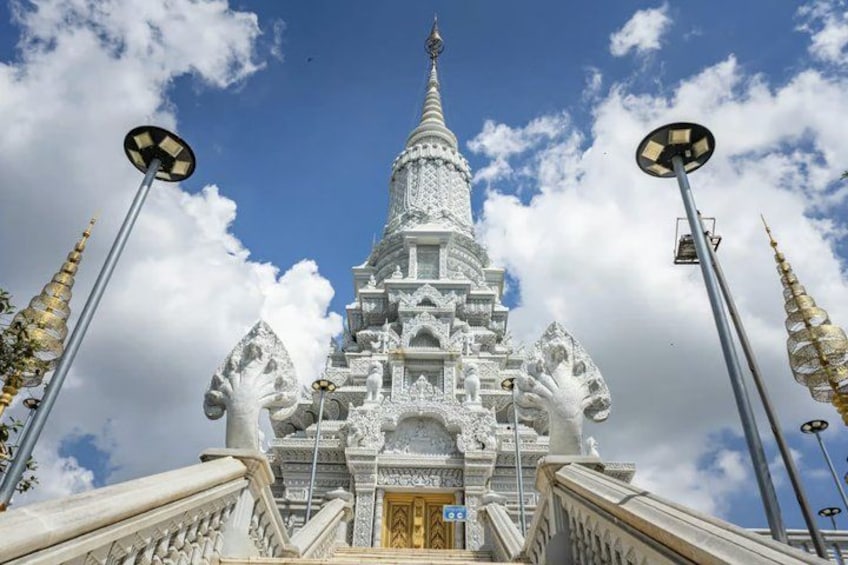Un templo blanco con una aguja puntiaguda, intrincados grabados y pináculos dorados. 1