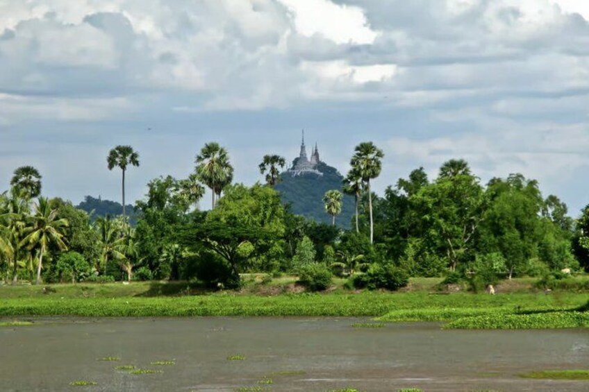Un paisaje con un templo en una colina, rodeado de vegetación y una masa de agua. 5