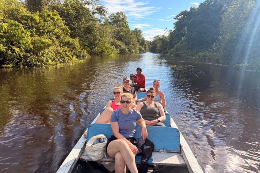 A group of people on a boat in a river surrounded by greenery. 2