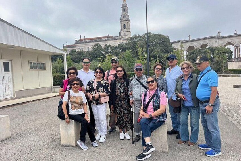 A group of people posing in front of a building with a clock tower in the background. 4