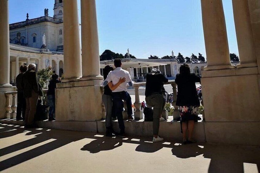 People standing and walking near a building with columns. 3