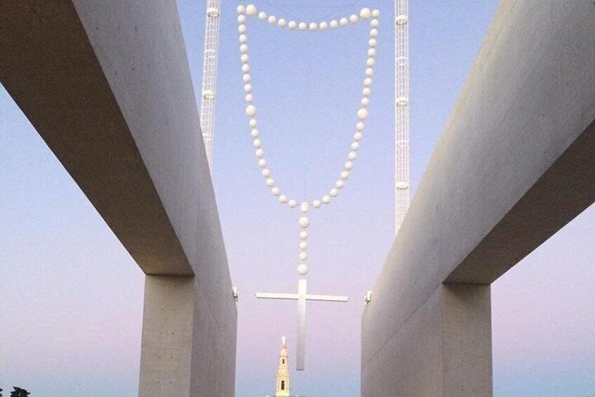 A bridge with a cross at the center and a tower in the background. 5