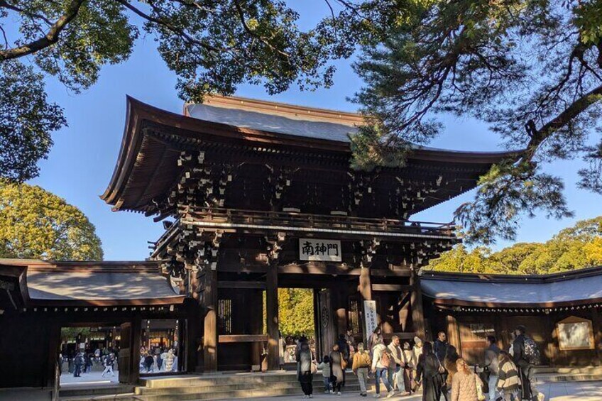 A traditional Japanese temple with a large wooden structure and people walking around. 5
