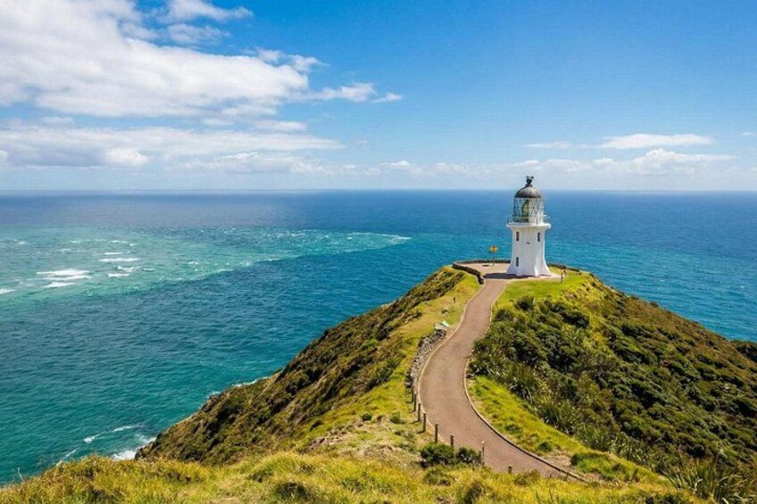 A lighthouse on a grassy cliff overlooking the ocean. 2