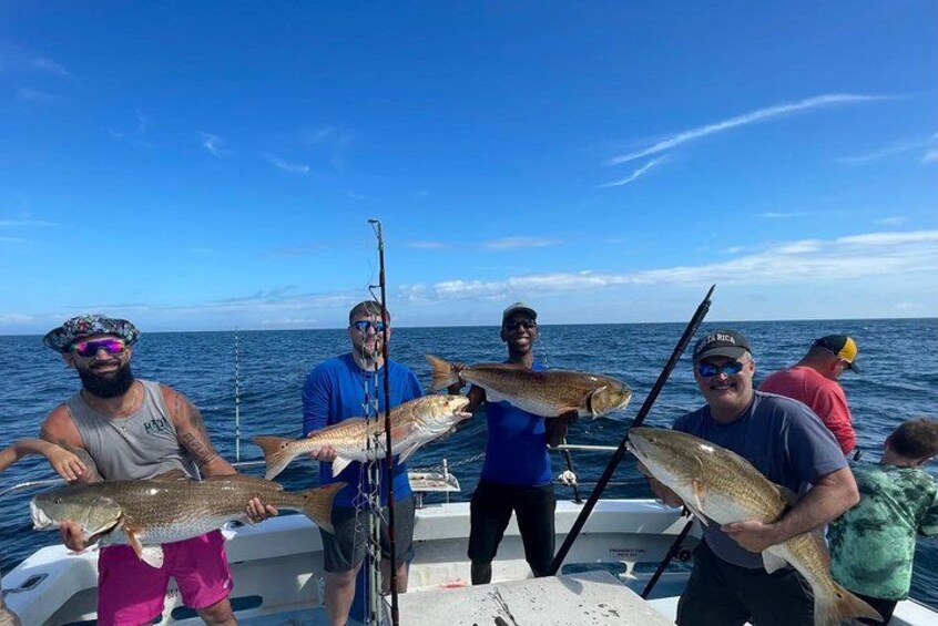 Un grupo de personas en un bote sosteniendo peces grandes. 1