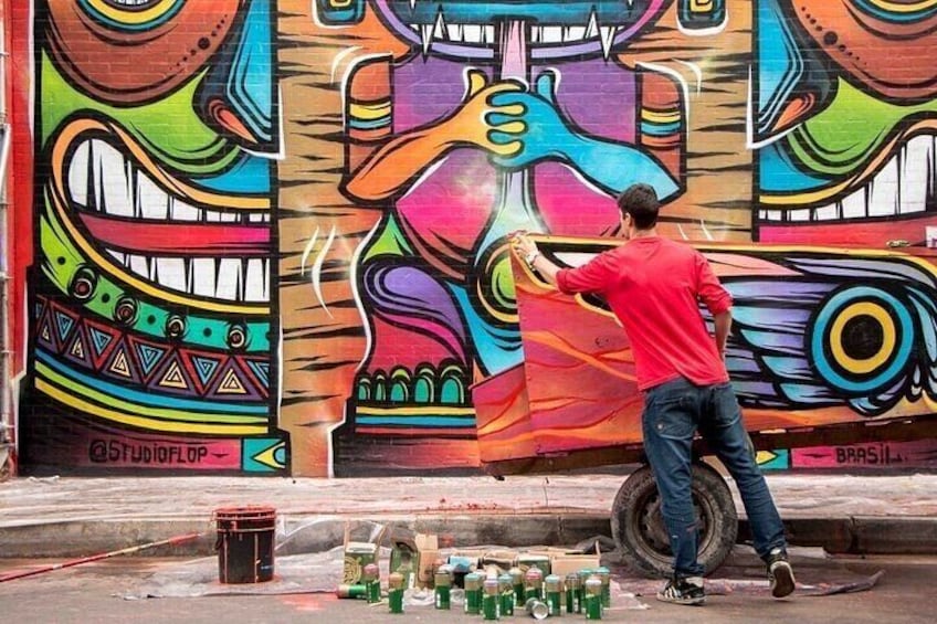 A person painting a colorful mural on a wall. 1