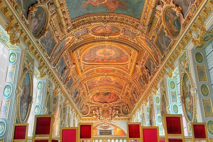 An ornate ceiling with intricate frescoes and gold accents. 1