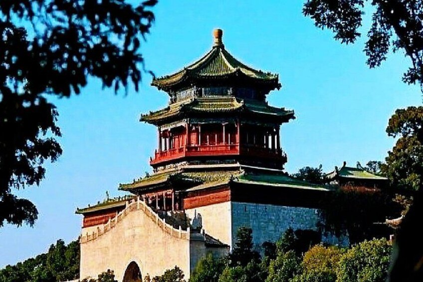 Una pagoda tradicional de varios niveles con tejado verde, rodeada de árboles y un cielo azul despejado. 4