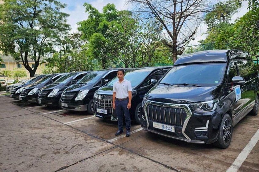 Una fila de camionetas SUV negras estacionadas en un estacionamiento con árboles al fondo. 1