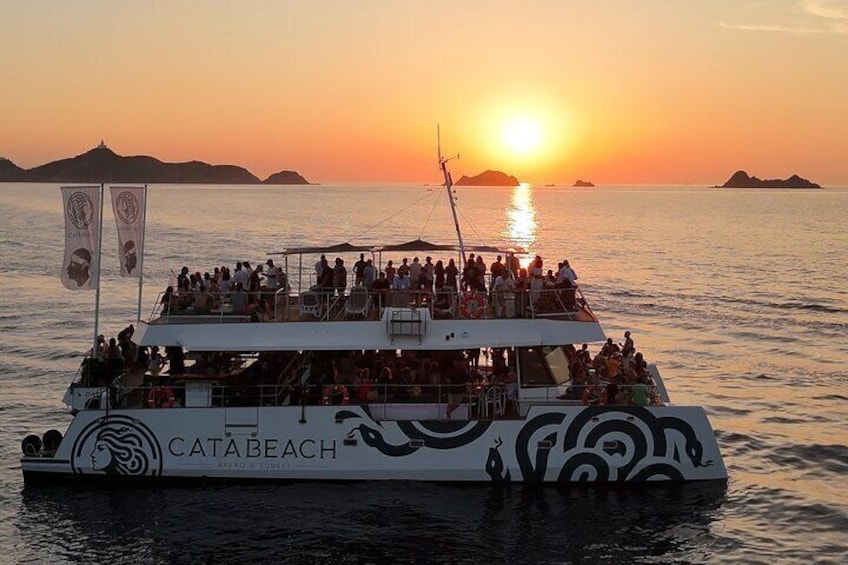 A boat named CATABEACH with passengers enjoying a sunset view. 1
