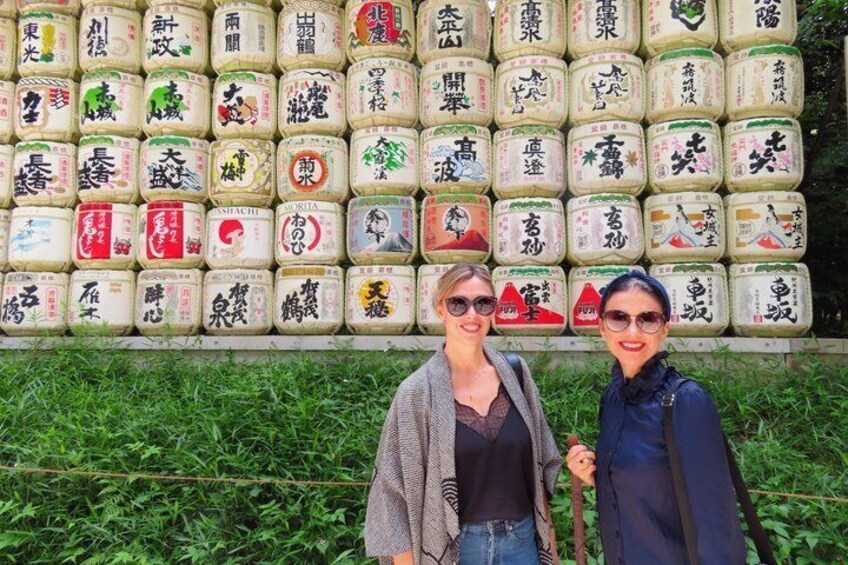 Two people standing in front of a wall of stacked containers with Chinese characters. 2