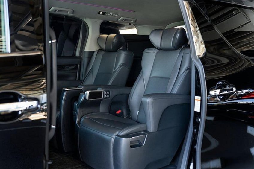 A car interior with black leather seats, a sunroof, and a visible door. 2
