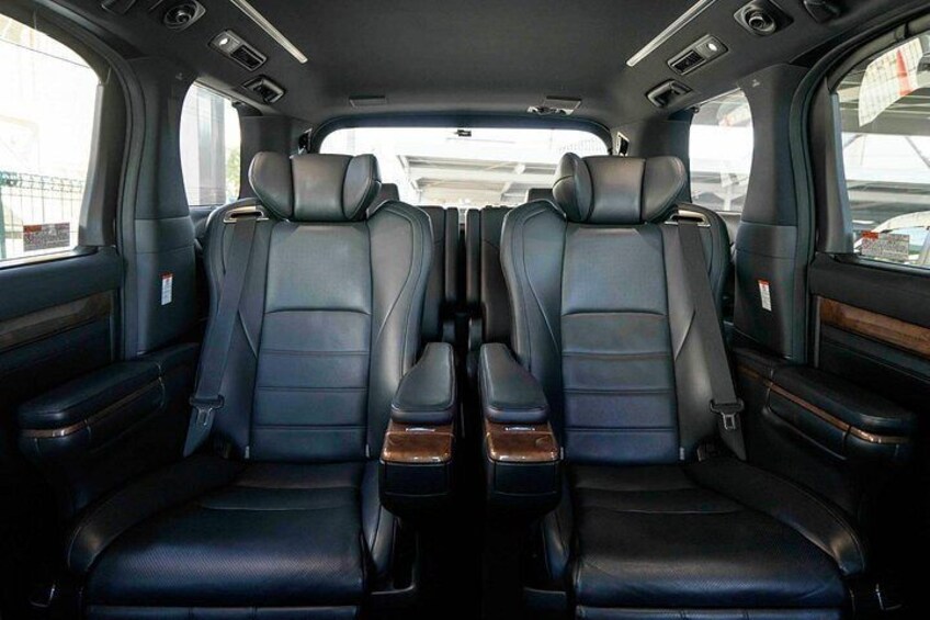 Een auto-interieur met twee zwarte leren stoelen, een schuifdak en een middenconsole. 5