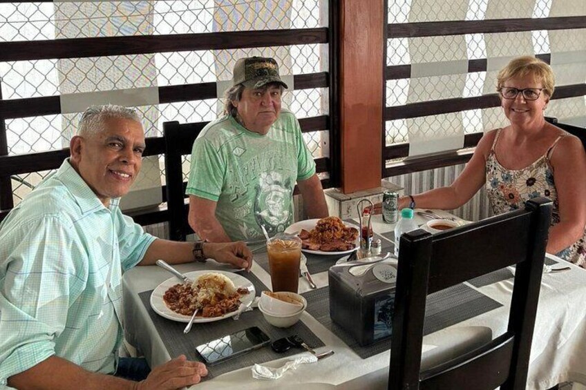 Three people dining at an outdoor restaurant with a table set for a meal. 2
