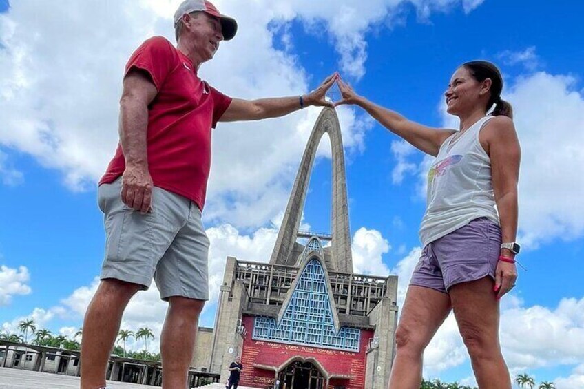 Due persone si danno la mano in segno di congratulazioni di fronte a un edificio moderno con un arco distintivo. 1