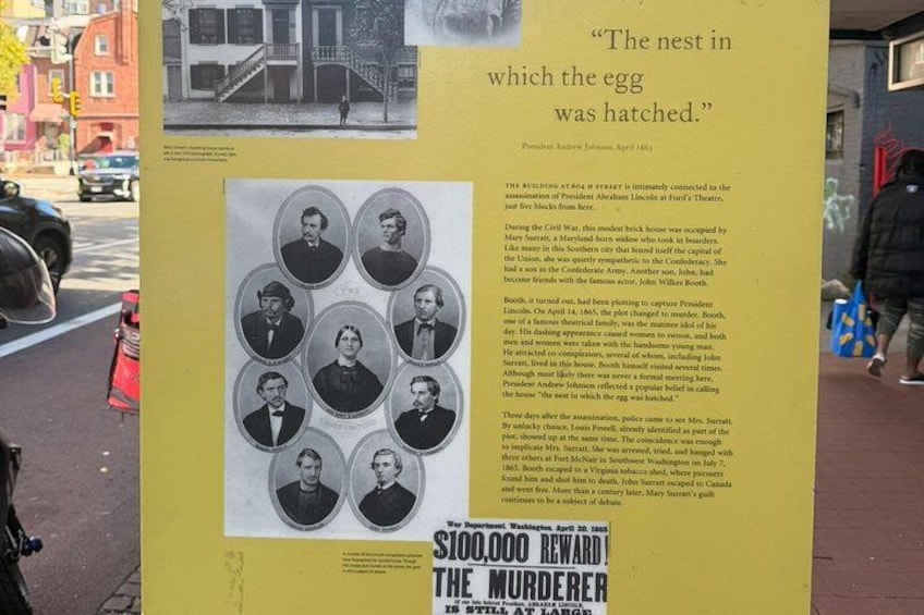 A historical plaque with a photograph of a building and text about a significant event. 3