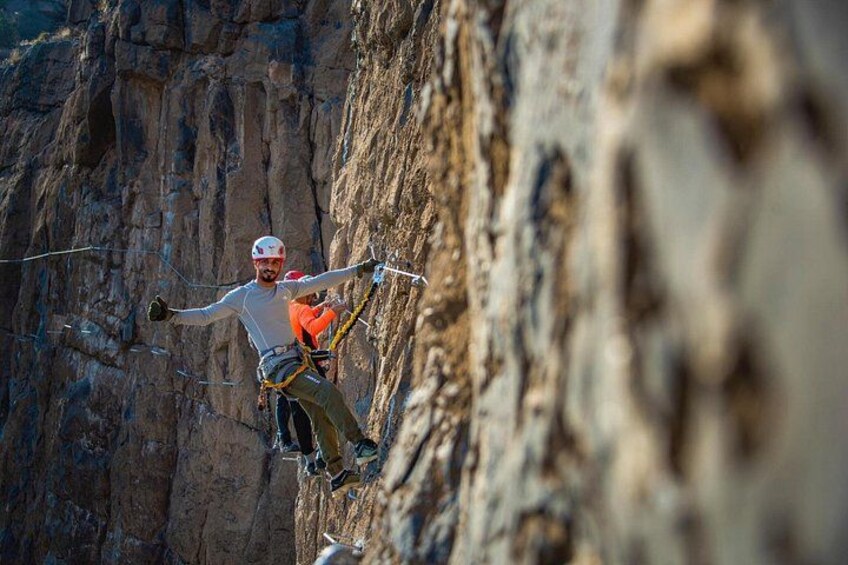 A person rappelling down a rocky cliff. 5