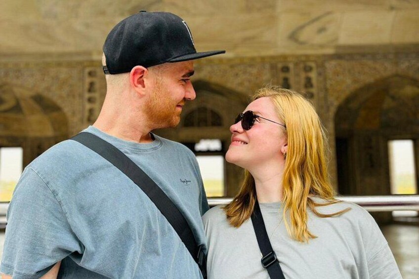 A man and a woman standing in a historical building with arches and columns. 4