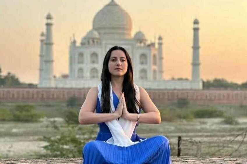 A person sitting in a meditative pose with the Taj Mahal in the background. 3