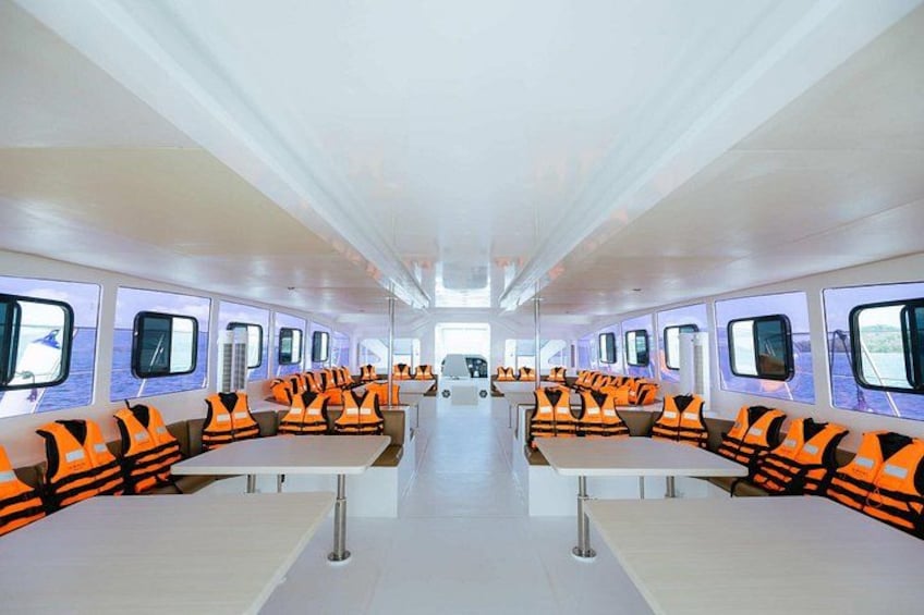 A modern, well-lit interior with rows of orange and black cushioned seating. 2