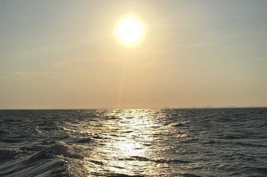 A sunset over the ocean with the sun low on the horizon. 4