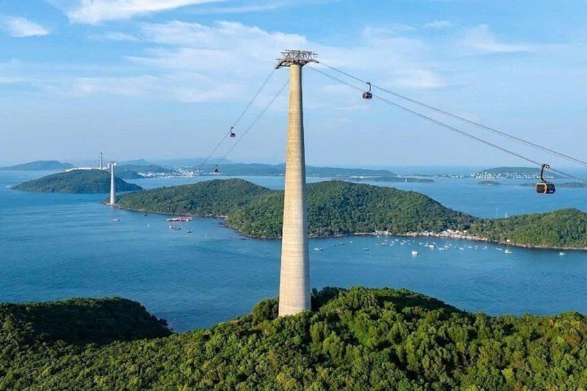 A cable car system, a large water body, and a bridge in the background. 1