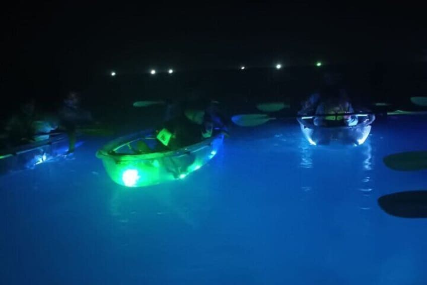 Twee verlichte boten op een wateroppervlak in de nacht. 1