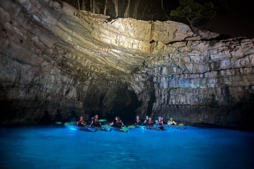 People kayaking in a cave with water. 3