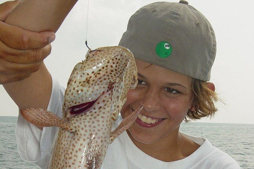 A person holding a spotted fish. 2