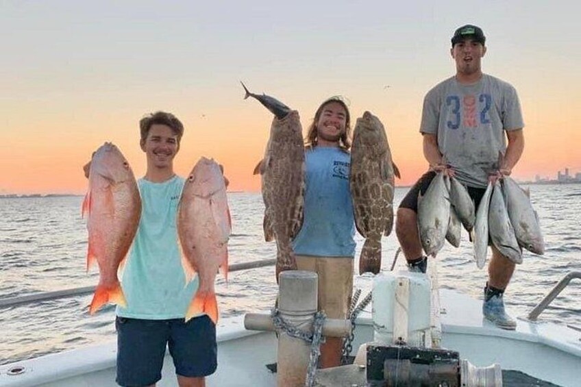 A boat with four people holding fish. 3