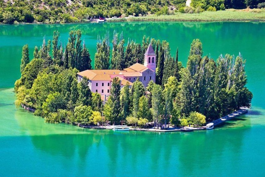 A small island with a church surrounded by trees and a body of water. 4