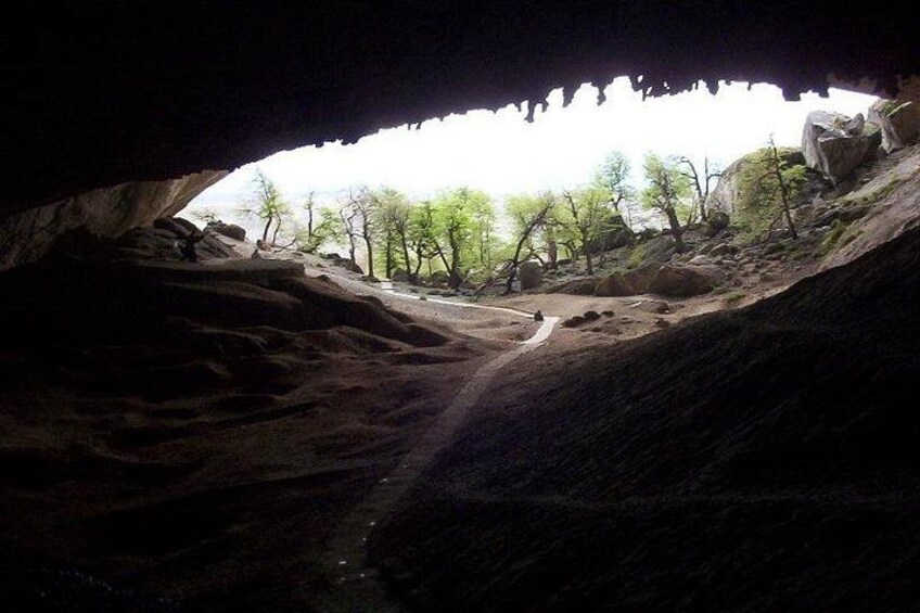 A cave entrance with a rocky interior and a view of trees outside. 3