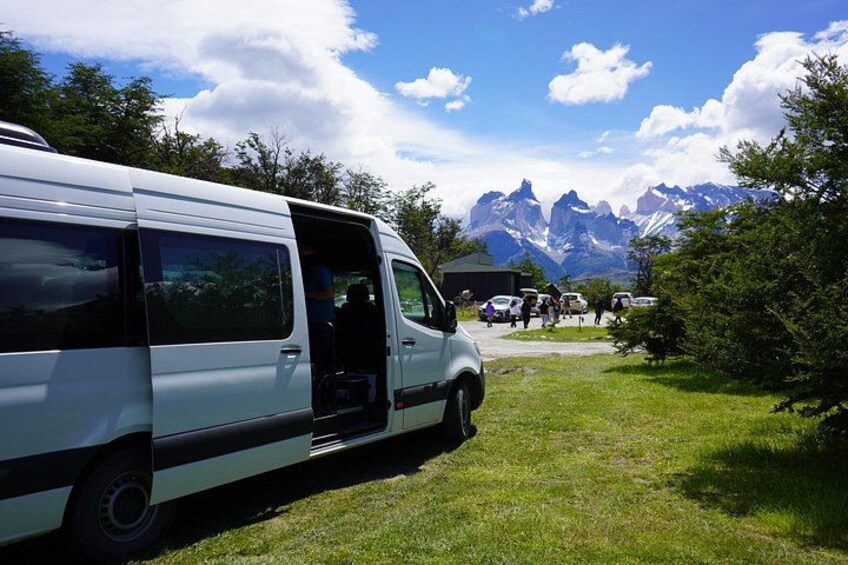 A white van parked on a grassy area with a mountainous landscape in the background. 2