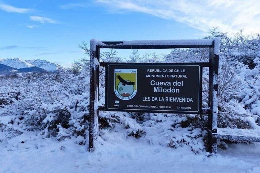A sign in a snowy landscape with mountains in the background. 4