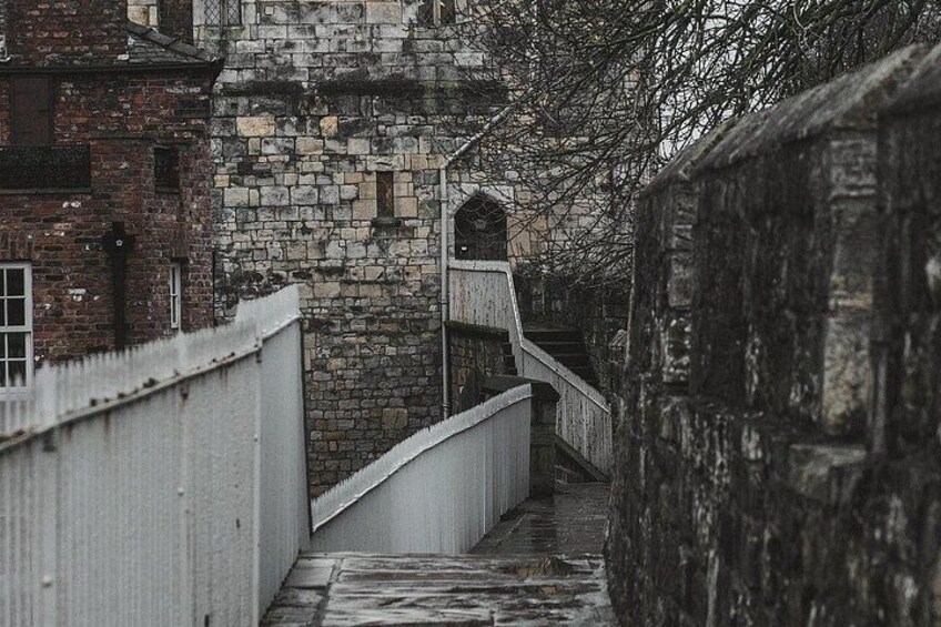 A stone staircase leading up to a building with a white railing. 4