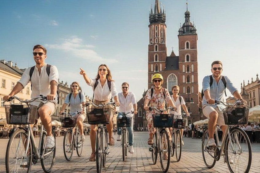 A group of people riding bicycles on a cobblestone street with a historic building in the background. 1