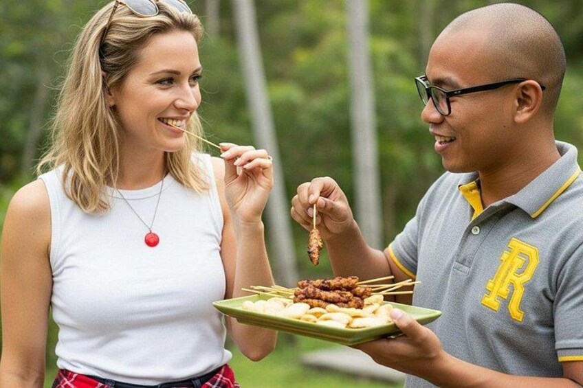 Dos personas sosteniendo un plato con comida, al aire libre con árboles de fondo. 3
