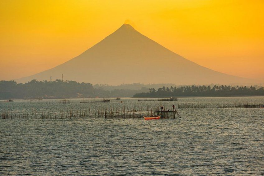 A sunset over a body of water with a mountain in the background. 3