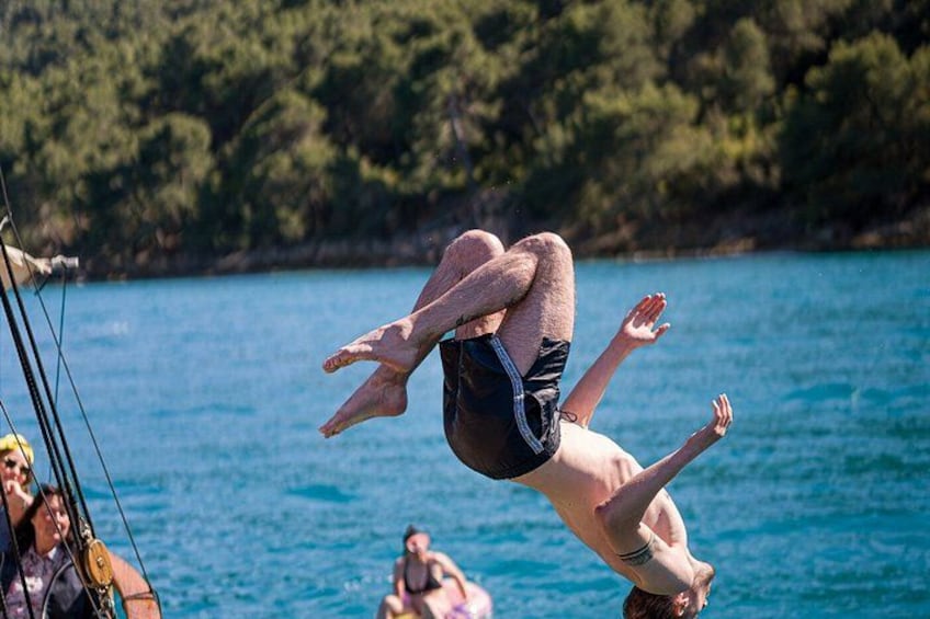 Una persona realiza un salto mortal hacia atrás desde un trampolín hacia el agua. 3