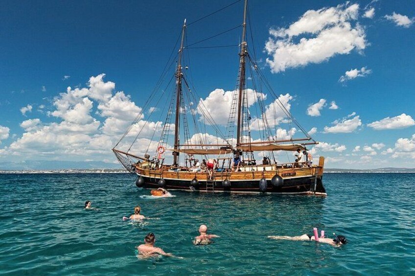 Un gran barco velero con gente nadando a su alrededor. 2