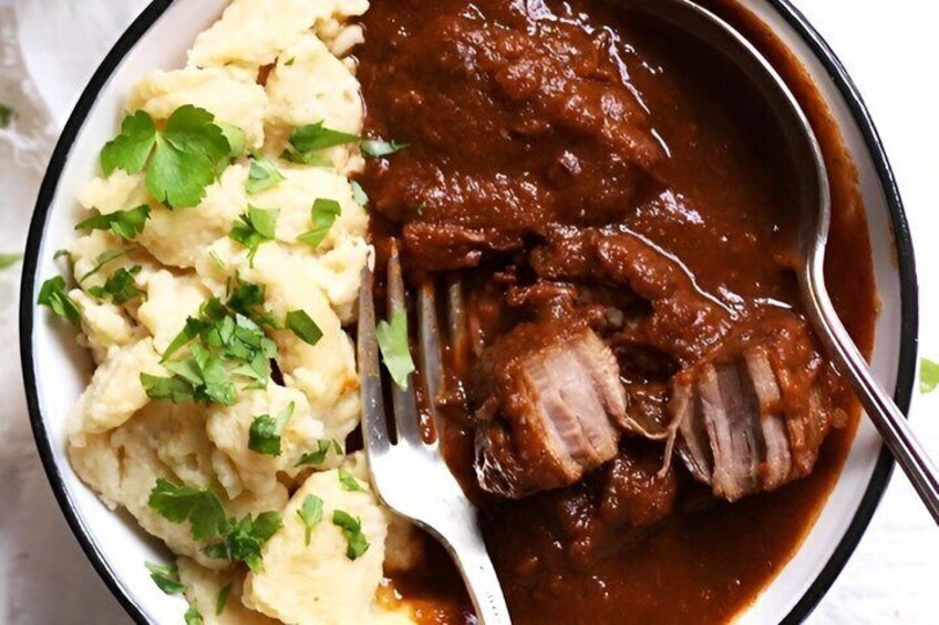 A plate of beef stew with mashed potatoes and garnished with parsley. 4