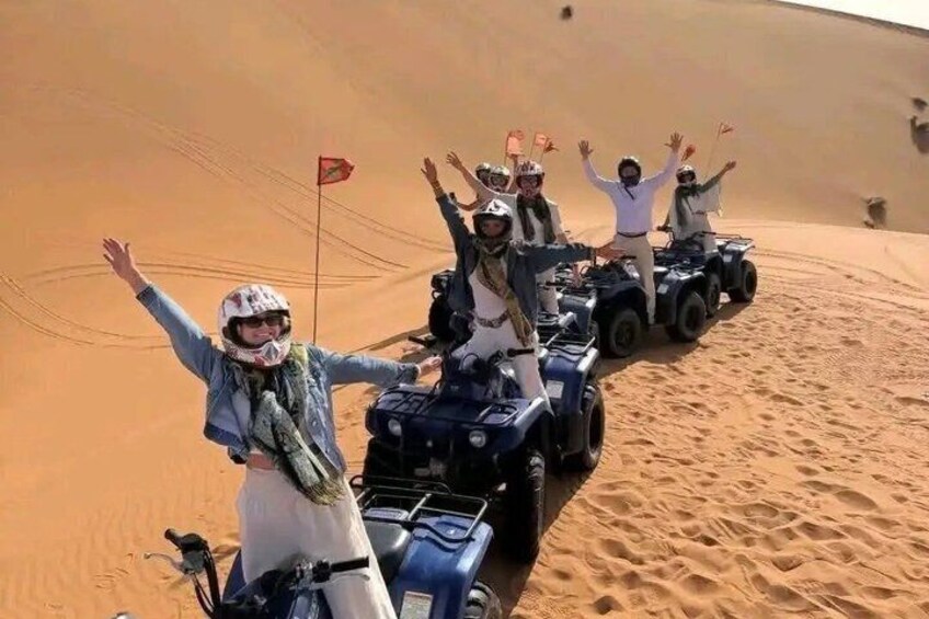 A group of people on ATVs in a desert with sand dunes. 4